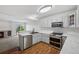 Modern kitchen with stainless steel appliances, light grey cabinets, marble countertops, and deck access at 10570 Echo Ct, Firestone, CO 80504
