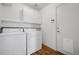 Clean, bright laundry room with side-by-side washer and dryer and overhead cabinets at 10570 Echo Ct, Firestone, CO 80504
