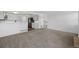 Open-concept living area flowing into kitchen with wood floors, neutral carpet, and stainless steel appliances at 10570 Echo Ct, Firestone, CO 80504