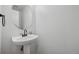 Bright powder room features pedestal sink and round mirror at 10570 Echo Ct, Firestone, CO 80504