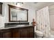 Bathroom featuring a vanity with dark wood cabinets and solid surface countertop, with a decorative shower curtain at 3390 S Ensenada Way, Aurora, CO 80013