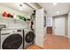 Convenient laundry area featuring modern washer and dryer units with shelving for storage at 3390 S Ensenada Way, Aurora, CO 80013