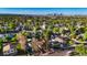 An aerial view showcasing houses and trees with the Denver skyline in the background at 3471 W Exposition Ave, Denver, CO 80219