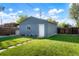 Blue detached garage with a white door and lush green grass at 3471 W Exposition Ave, Denver, CO 80219