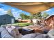 Backyard featuring a large deck with outdoor seating and a fire pit beneath a sun shade at 3471 W Exposition Ave, Denver, CO 80219