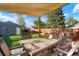 Backyard featuring a large deck with outdoor seating beneath a sun shade and a fenced lawn at 3471 W Exposition Ave, Denver, CO 80219