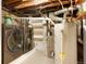 Basement utility area featuring a washer, dryer, water heater, and storage shelving at 3471 W Exposition Ave, Denver, CO 80219