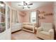 Charming Bedroom with pink walls, hardwood floors, and a white crib and armchair at 3471 W Exposition Ave, Denver, CO 80219