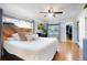 Bright main bedroom with a decorative wood headboard, hardwood floors, a ceiling fan, and a walk-in closet at 3471 W Exposition Ave, Denver, CO 80219