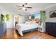 Bright main bedroom with hardwood floors, a ceiling fan, and views of hanging plants at 3471 W Exposition Ave, Denver, CO 80219