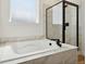 Relaxing soaking tub next to a glass-enclosed shower in a modern bathroom with marble tile at 42974 Colonial Trl, Elizabeth, CO 80107