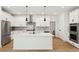 Modern kitchen with white cabinetry, stainless steel appliances, a center island, and hardwood floors at 42974 Colonial Trl, Elizabeth, CO 80107