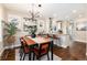 Well-lit dining room with a wooden table and chairs, view into kitchen with barstool seating at 4244 Grove St, Denver, CO 80211