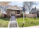 Charming brick bungalow with inviting front porch and well-manicured lawn at 4244 Grove St, Denver, CO 80211