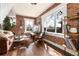 Inviting living room featuring exposed brick, large windows, hardwood floors, and comfortable seating at 4244 Grove St, Denver, CO 80211