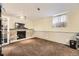 Cozy basement with fireplace, carpet flooring, wainscotting, and natural light at 9120 W Bellwood Pl, Littleton, CO 80123