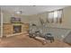 Versatile basement space with brick fireplace and fitness equipment at 9120 W Bellwood Pl, Littleton, CO 80123