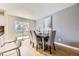 Elegant dining area with modern table, chairs, hardwood floors, sliding glass door, and backyard view at 9120 W Bellwood Pl, Littleton, CO 80123