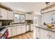 Well-lit kitchen with granite countertops, stainless steel appliances, white cabinetry, and backyard access at 9120 W Bellwood Pl, Littleton, CO 80123