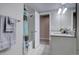 Bathroom with a shower-tub combo, white vanity, and a gray accent wall at 4483 Fell Mist Way, Castle Rock, CO 80109