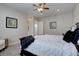 Bedroom featuring a queen bed with a white comforter and decorative pillows, ceiling fan and neutral walls at 4483 Fell Mist Way, Castle Rock, CO 80109