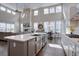Bright kitchen featuring stainless steel appliances, white cabinets, a large island, and an open floor plan at 4483 Fell Mist Way, Castle Rock, CO 80109