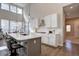 Bright kitchen with white cabinets, stone countertops, a large island, and modern appliances at 4483 Fell Mist Way, Castle Rock, CO 80109