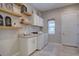 Laundry room with washer and dryer, white cabinets, and open wood shelving at 4483 Fell Mist Way, Castle Rock, CO 80109