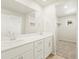 Bright bathroom featuring a double vanity and a large mirror, plus a walk-in closet, all in a modern style at 20982 E 66Th Ave, Aurora, CO 80019