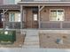 Inviting front porch featuring brick accents, a covered entry, and a well-manicured landscape at 20982 E 66Th Ave, Aurora, CO 80019