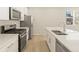 Modern kitchen features a gas range and a large island with stainless steel sink at 20982 E 66Th Ave, Aurora, CO 80019