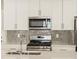 Modern kitchen features stainless steel appliances, stylish backsplash, and quartz countertops at 20982 E 66Th Ave, Aurora, CO 80019