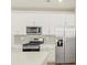 Bright kitchen features white cabinets, stainless steel appliances, and custom backsplash at 20982 E 66Th Ave, Aurora, CO 80019