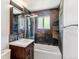 Bathroom featuring a bathtub, tiled shower, modern vanity, and unique wall tiles at 5480 W Iowa Ave, Lakewood, CO 80232