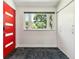 Bright entryway features a red door, closet, plush carpet and a window view of lush greenery at 5480 W Iowa Ave, Lakewood, CO 80232