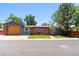 Charming single-story home with a modern design, wood accents, gray siding, and a well-manicured lawn at 5480 W Iowa Ave, Lakewood, CO 80232