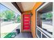 Contemporary covered entryway showcasing a vibrant red door, modern fixtures, and natural light at 5480 W Iowa Ave, Lakewood, CO 80232