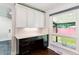 A home office features a black desk with white cabinets and a window for natural lighting at 5480 W Iowa Ave, Lakewood, CO 80232