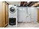 Functional laundry room with stacked washer and dryer in a neutral-toned basement at 5480 W Iowa Ave, Lakewood, CO 80232