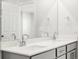 Bright bathroom featuring double sinks, large mirror and gray vanity with plenty of storage at 742 N Tempe St, Aurora, CO 80018