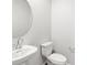 Clean half bathroom with a contemporary sink, a round mirror, and a toilet at 742 N Tempe St, Aurora, CO 80018