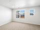 Bright bedroom featuring neutral carpet, white walls, and two windows at 742 N Tempe St, Aurora, CO 80018
