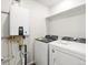 Laundry room with front load washer and dryer, tankless water heater and overhead shelving at 742 N Tempe St, Aurora, CO 80018