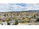 Expansive aerial view of a neighborhood with mature trees and mountain views in the distance at 7746 W Quarto Dr, Littleton, CO 80128