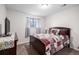 Comfortable bedroom with a decorative quilt, side table with lamp, and soft, neutral-colored walls at 7746 W Quarto Dr, Littleton, CO 80128