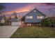 Charming two-story home with blue siding, brick accents, well-kept lawn, and attached two-car garage at 7746 W Quarto Dr, Littleton, CO 80128