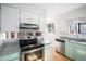 Well-lit kitchen with stainless steel appliances, granite counters, and ample cabinet space at 7746 W Quarto Dr, Littleton, CO 80128