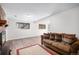 Spacious living room with wood-look floors, comfortable sofa, and windows providing natural light to the space at 7746 W Quarto Dr, Littleton, CO 80128