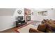 Cozy living room with brick fireplace, wood mantel, mounted TV, and comfortable seating with decorative pillows at 7746 W Quarto Dr, Littleton, CO 80128