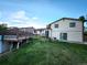 Spacious backyard featuring a well-kept lawn and two-story home with wooden deck, flower garden, and sliding glass door at 3216 S Granby Way, Aurora, CO 80014